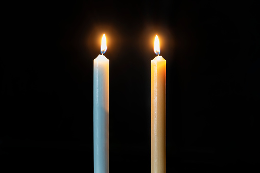 Two big burning candles. Bright light on dark background. Birthday party. Romantic evening on Valentine. RIP darkness template. mourn