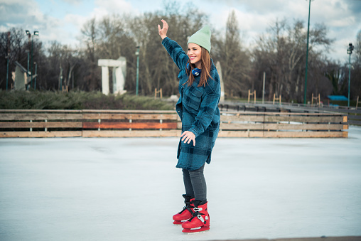Young woman enjoy skating at city ice rink