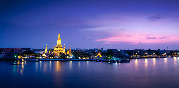 Wat arun temple in bangkok, thailand Twilight view of Wat Arun across Chao Phraya River during sunset in Bangkok, Thailand wat arun stock pictures, royalty-free photos & images