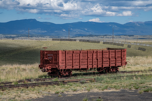 Old railroad freight car on narrow gauge tracks in rural prairie of Colorado of western USA in North America.