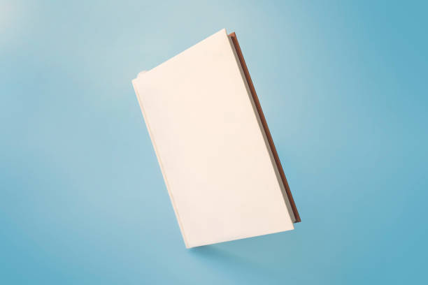 istock a white book on a blue background. Empty space on the cover for design and text 1651636759