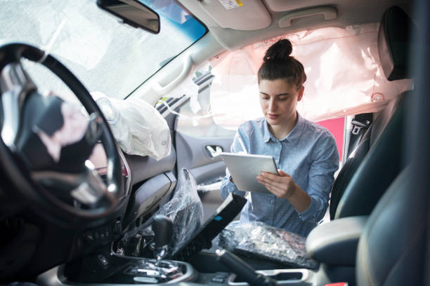 Insurence adjuster inspecting damages on the inside of a crashed vehicle. Female Insurence adjuster using digital tablet to  inspect damages on the inside of a crashed vehicle. broken digital tablet note pad cracked stock pictures, royalty-free photos & images