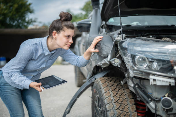 On site inspection.Insurance agent inspecting vehicle damage. On site inspection.Female Insurance agent inspecting vehicle damage and  using digital tablet. broken digital tablet note pad cracked stock pictures, royalty-free photos & images