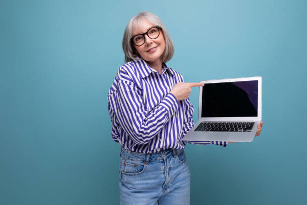 istock middle aged woman mastering laptop with mockup on bright studio background 1651643741
