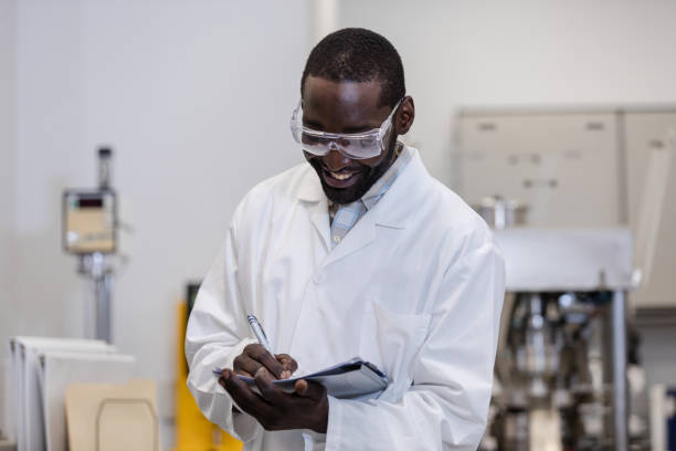 istock Mid adult scientist smiles while writing down the experiment results 1651656630
