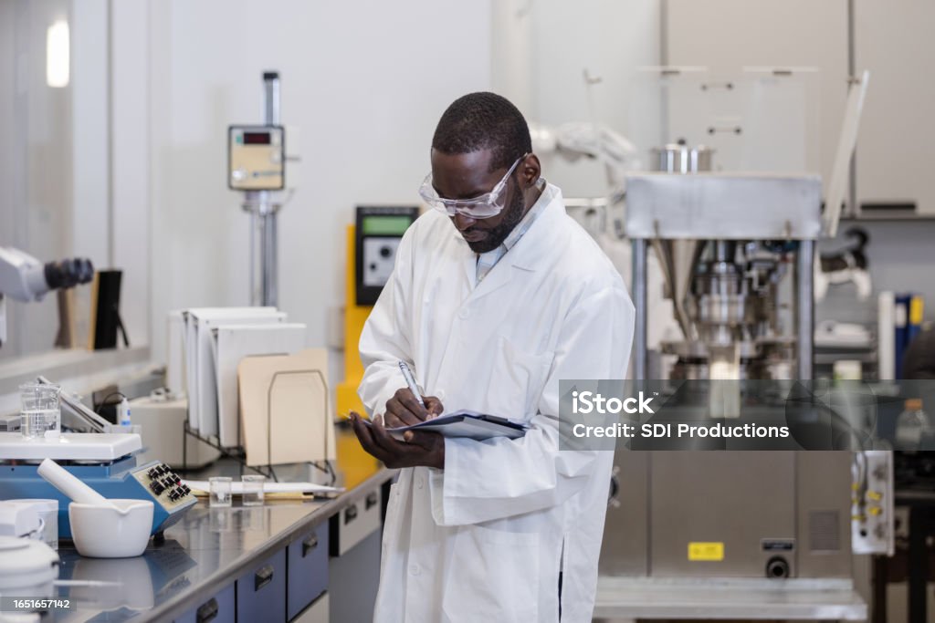 Lab Supervision Male Laboratory Supervisor Makes Notes In His Lab Report While Making ...