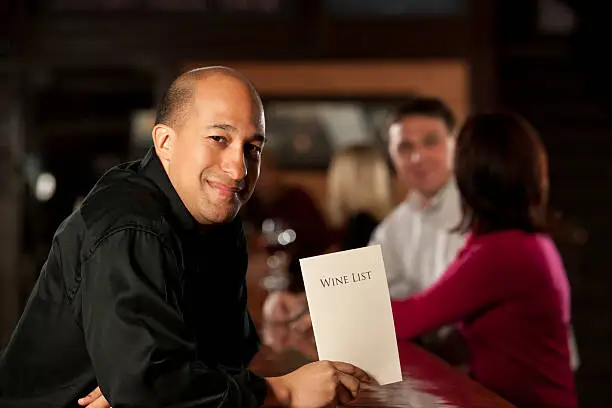 Photo of Bartender with wine list, Patrons In Restaurant