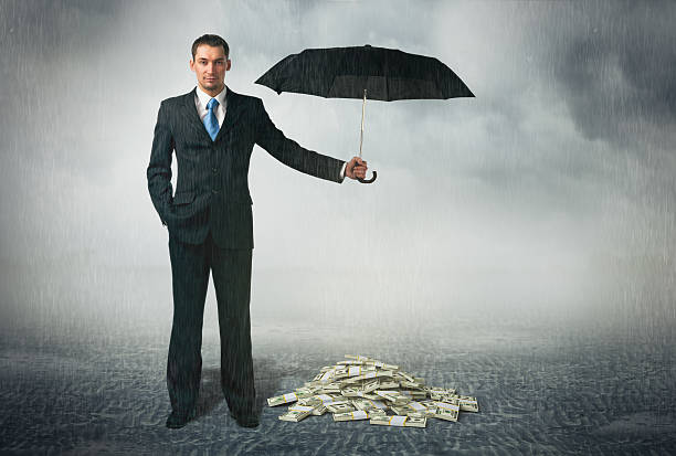 бизнесмен с зонтиком - security umbrella rain currency стоковые фото и изображения