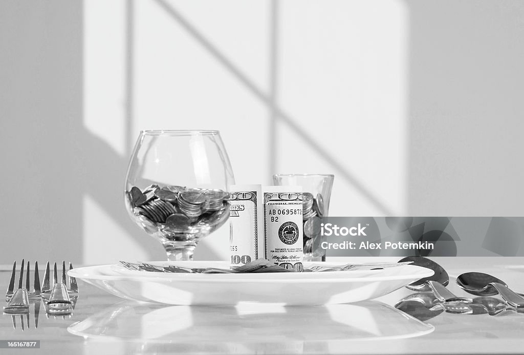 Table served with money's dishes Table served with money's dishes. Coins in the goblet, dollars on the plate. Banking Stock Photo