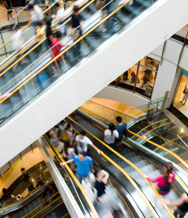 People in motion in escalators at the modern shopping mall.