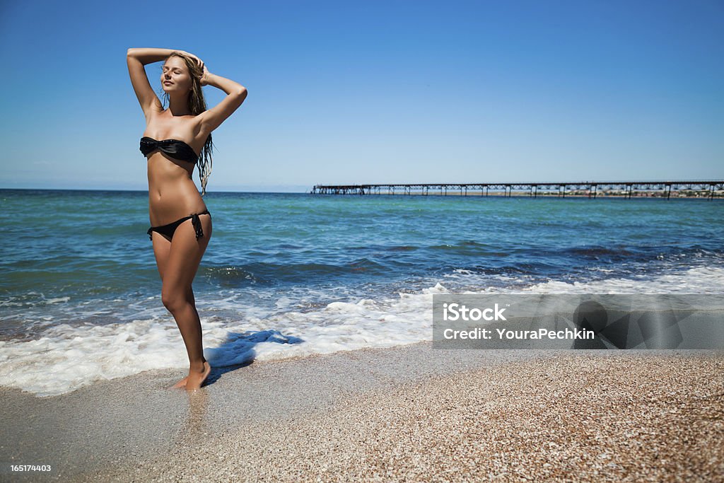 Young woman at blue sea Beautiful woman on beach 25-29 Years Stock Photo