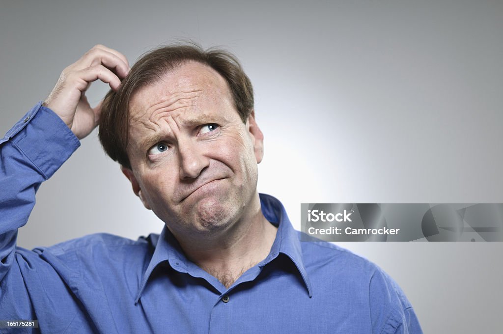 Confusion Portrait A Caucasian man in his 50's scratching his head and wondering.  Confusion Stock Photo