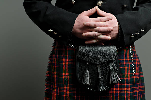 Scottish Kilt and Purse Detail of a Scottish man's hands clasped over his kilt and purse. kilt stock pictures, royalty-free photos & images