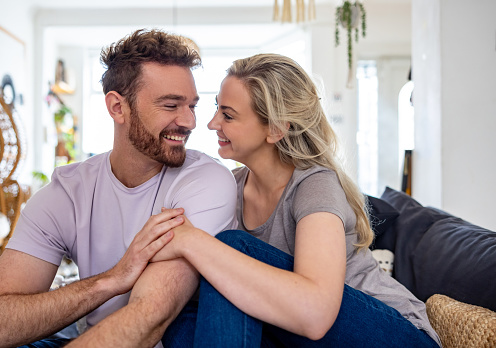 Affectionate couple relaxing at home and looking very happy - relationship concepts