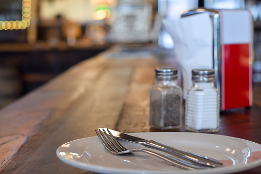 Plate with cutlery on a table at a diner