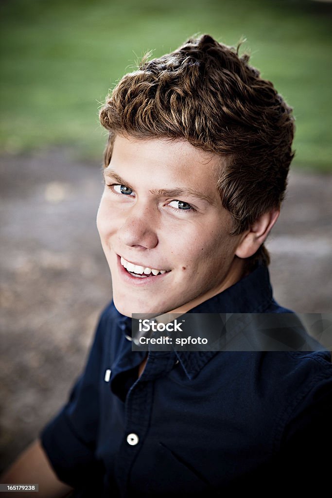 smiling portrait Young man looking over his shoulder, smiling at the camera. Button Down Shirt Stock Photo