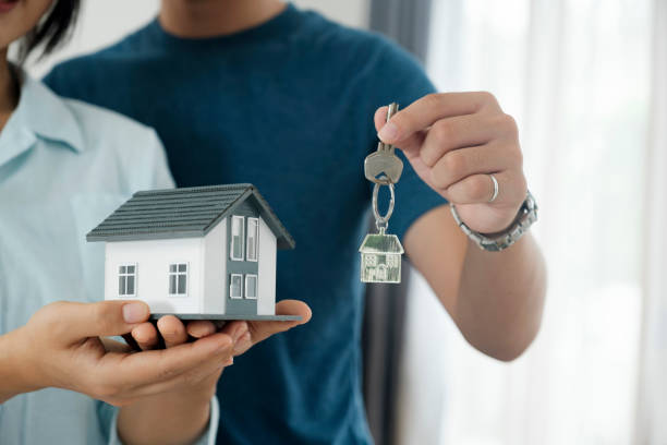 Happy young couple buying a new house receiving the keys. stock photo