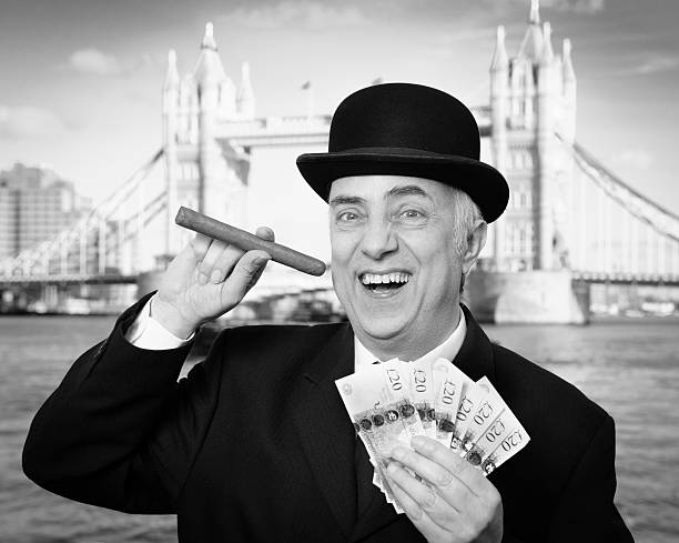 City Banker British city gent with a fat cigar and a handful of cash laughing his socks off at his ill gotten gains. A nice big bonus for this fat cat . A right Banker - so to speak! greedy corporation stock pictures, royalty-free photos & images