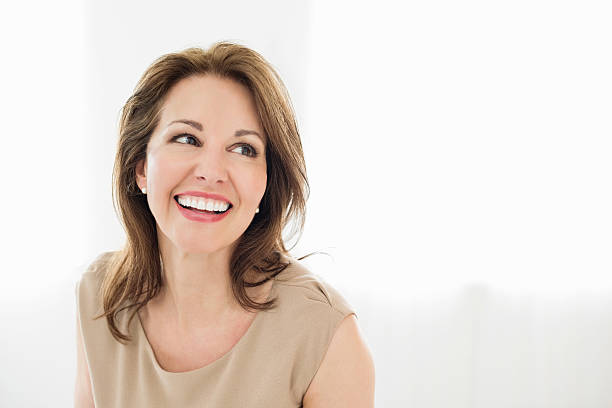 Cheerful Mature Woman Looking Away Cheerful mature woman looking away isolated over white background women beautiful studio shot isolated on white stock pictures, royalty-free photos & images