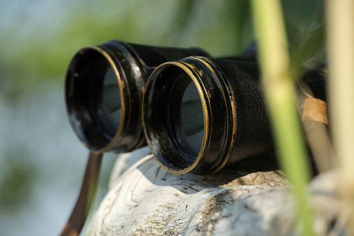 Binoculars resting on a rock the image convey a sense of exploration or observation