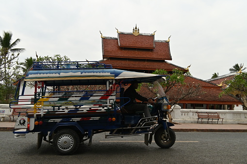 Luang Prabang, Laos - January 27, 2023 - The auto rickshaw, called tuk-tuk is a widely used form of urban transport in many asian cities. The name is onomatopoeic, mimicking the sound of a small (often two-cycle) engine. It is particularly popular where traffic congestion is a major problem