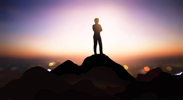 成功の頂点に立つことは人生の究極の目的です。 夕暮れの山の頂上に立って、空を見上げる人々。仕事は成功につながります。 - powerful owl ストックフォトと画像