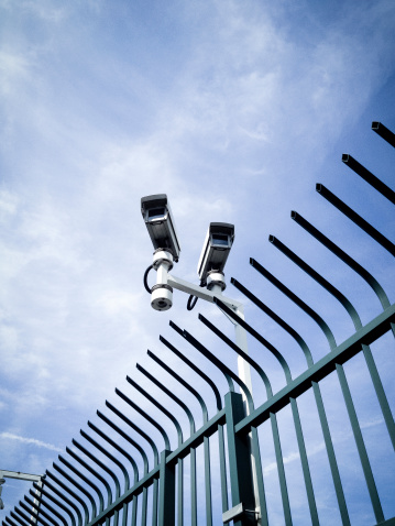 Video surveillance cctv camera above a security fence.