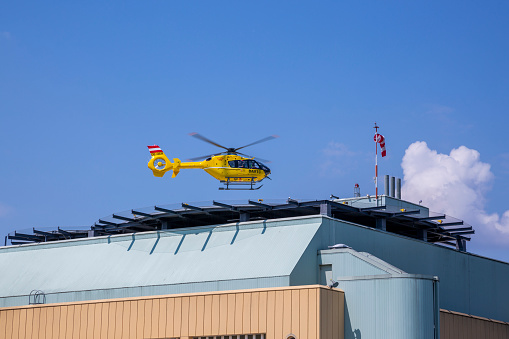 Vienna, Austria - June 14, 2023: An ambulance helicopter lands on the roof of the Donaustadt Clinic building in Vienna