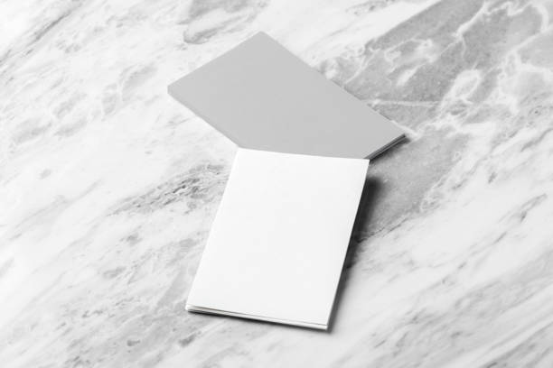 istock Vertical business card mockup on white marble table background 1651990347