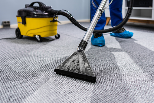 Modern vacuum cleaner on carpet. Space for text