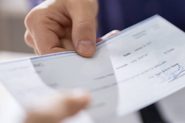 istock Businessperson Hands Giving Cheque 1652006031