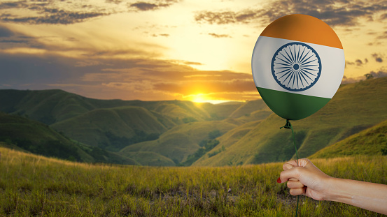 Human hand holding a balloon with the Indian flag color. India Independence Day concept