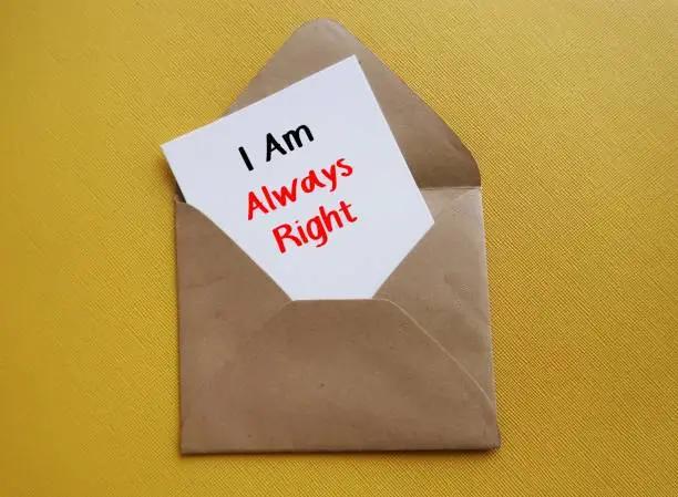 Photo of White card in envelope on yellow background I AM ALWAYS RIGHT, means one who so keen to be always right, hard to accept feelings or viewpoint of others