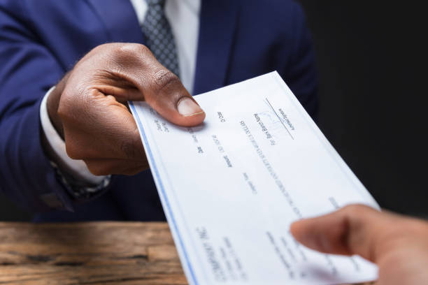 istock Businessman Giving Cheque To His Colleague 1652009246