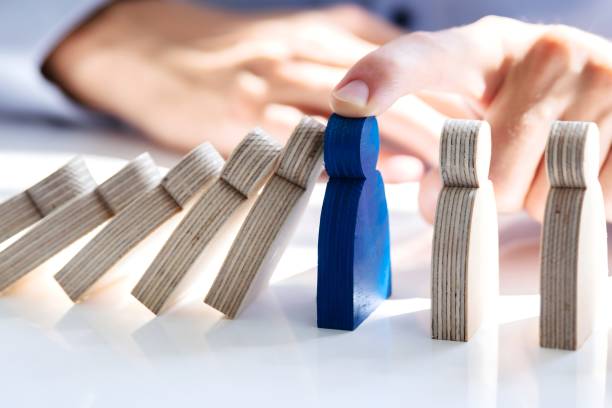 Businessperson Stopping Falling Persons On Desk Close-up Of A Male Hand Stopping The Persons From Falling On Desk prevention stock pictures, royalty-free photos & images