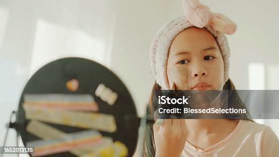 istock Happy mixed Asian preteen girl applying clay facial mask at home, skincare routine, self care and wellness concept 1652013135