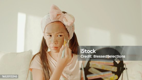 istock Happy mixed Asian preteen girl applying clay facial mask at home, skincare routine, self care and wellness concept 1652013245