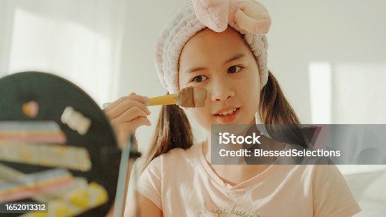 istock Happy mixed Asian preteen girl applying clay facial mask at home, skincare routine, self care and wellness concept 1652013312