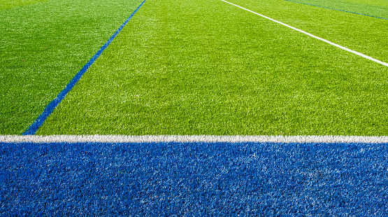 Beautiful Football field. White and blue lines on green artificial grass of a football field. Football field, Futsal field, green grass sport outdoor. Nobody, selective focus