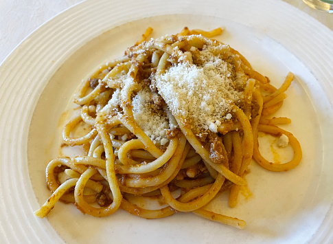 Spaghetti with Bolognese sauce in a white dish.