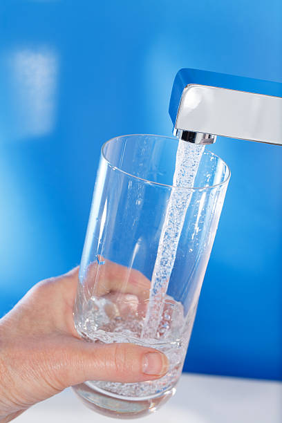 istock Filling up a glass of water . Blue background. 165205569