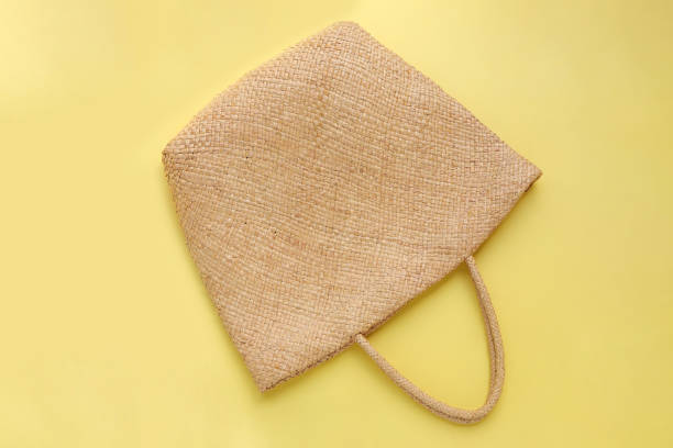 Hessian bag covered by transparent leaves with gift tag flat lay timber backdrop with copy space for your text