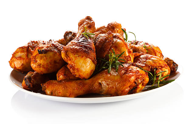 A plate of roasted chicken drumsticks stock photo