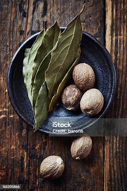 Bay Leaves And Nutmeg On A Small Plate Stock Photo - Download Image Now - Bay Leaf, Brown, Close-up