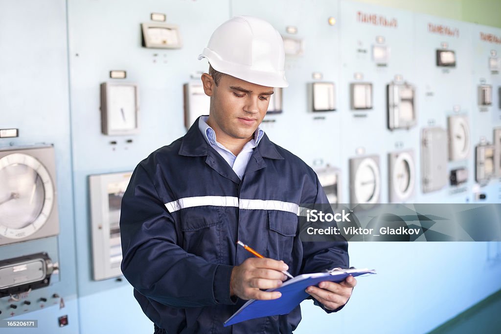 Jovem sorridente Engenheiro tomar notas em sala de controle - Foto de stock de Fábrica royalty-free