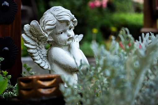 Small statue of angel on tombstone