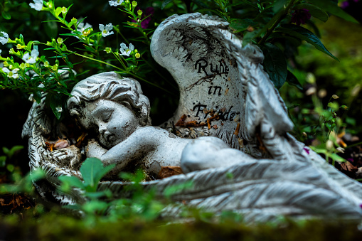 Small statue of angel on tombstone