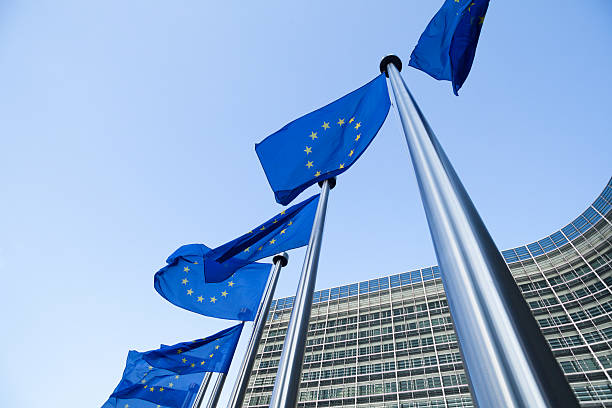 europäische flaggen vor dem berlaymont-gebäude in brüssel - europaflagge stock-fotos und bilder