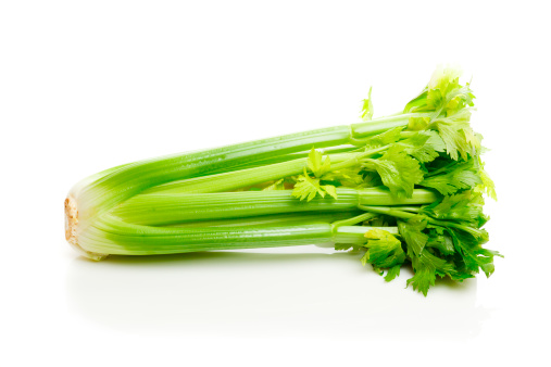 Bunch of celery isolated on white on a reflective surface.