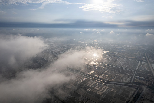 Aerial view of houses and salt fields in a foggy town